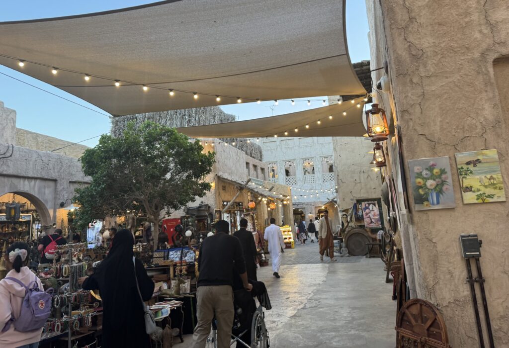 Historische Gasse im Al Fahidi Viertel in Dubai mit Souk-Ständen und Besuchern bei Abendlicht