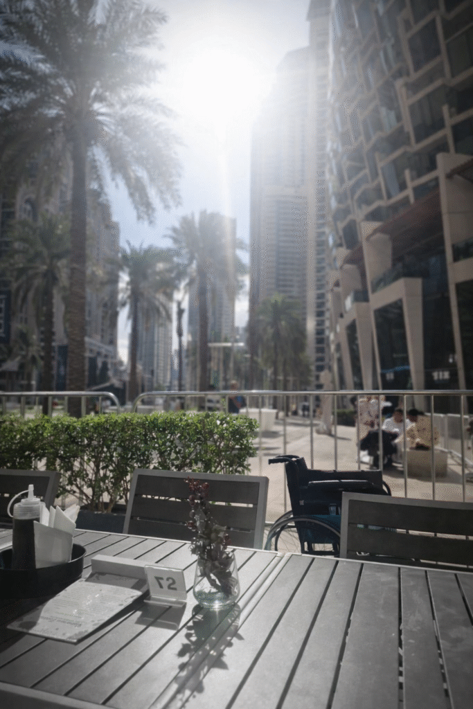 Sonniger Tag in Dubai mit Palmen und Straßencafé in urbaner Umgebung