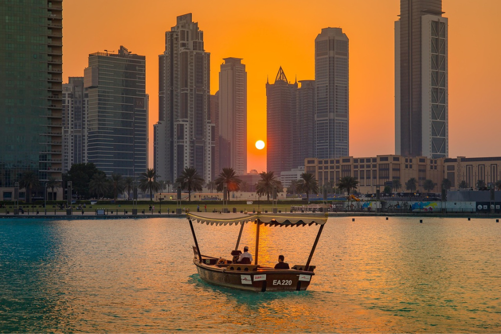 Dubai Wetter im April: Holzboot vor Dubais Skyline bei Sonnenuntergang, warmes Frühlingswetter im April