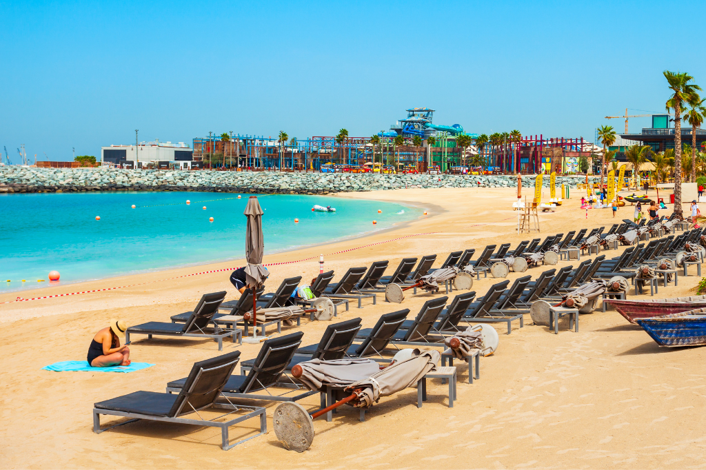 Strandhotels in Dubai, Palm West Beach in Dubai mit leeren Strandliegen, goldenem Sand und türkisblauem Wasser
